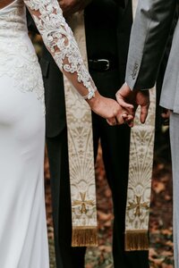 Close-up of bride and groom's hands together showing their wedding rings
