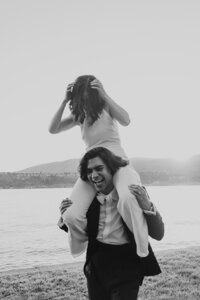 Candid moment with a bride on top of groom's shoulders