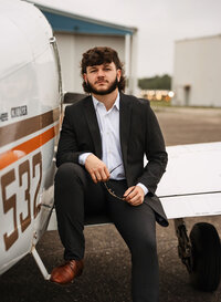 Senior portrait at a small hangar near Mobile International Airport in Mobile, Alabama — posing near airplane