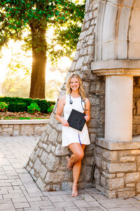 Ortho graduate leaning on the bricks of the Trevecca University bell tower