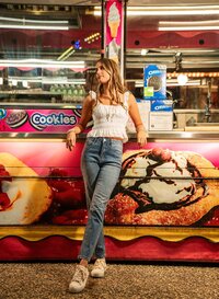 Senior portrait at the Greater Gulf State Fair in Mobile, Alabama — leaning against a cookie
stand, looking to the side.
