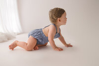 Baby crawls away from the camera during Baby Milestone Portrait Session at Holy City Babies Portrait Studio in Charleston, SC.