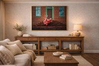 Framed portrait of a child in a dusty pink gown displayed above a warm wood console in a neutral living room