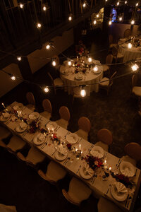 Elegant wedding table setup with gold cutlery, crystal glasses, and lush floral centerpieces at a historic Prague venue