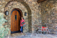 Lifestyle branding image of a Bend Oregon business owner standing in the doorway of a stone building