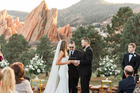 A couple exchanging rings at Arrowhead Gulf Club by Jackelynn Noel Photography.