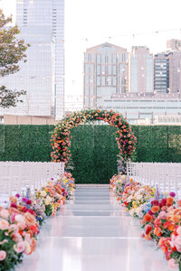 Colorful bright rainbow flowers down aisle and altar
