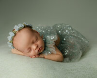 Newborn baby sleeping on a pale green blanket in a sparkly tulle outfit. Photographed by Inland Empire newborn photographer Kaitlyn Dawn Photography.