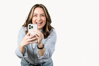 content creator poses with her phone and smiles to the camera