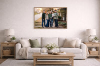 Framed family portrait displayed above sofa in neutral living room featuring a downtown New Bern family photography session on a brick walkway near Tryon Palace