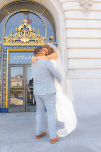 bride and groom in front of san francisco city hall doors