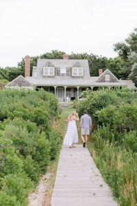Couple walk on boardwalk in Nantucket.