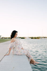 Beautiful pregnant woman sitting by the marina on Miami Beach at golden hour