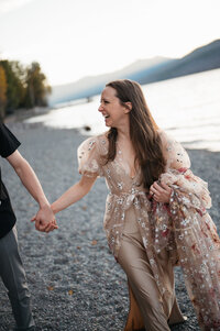Adventure Elopement Couple Holds Hands on Beach
