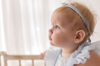 Baby gazes at her parents during her 1st birthday photoshoot at Holy City Babies Portrait Studio in Charleston, SC.