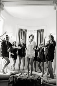 A candid, documentary style wedding photography moment of a bride and her bridesmaids celebrating, preserving the atmosphere and emotion of the morning.
