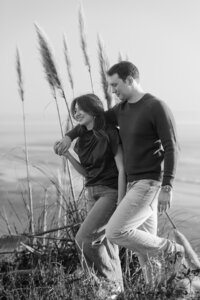 engagement couple walking on beach by palm grass in santa cruz. bnw