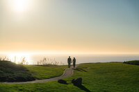 seascape resort couple walking along pathway into sunset