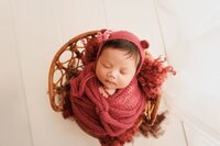 Neutral color newborn photography in Sacramento featuring a peacefully sleeping baby wrapped in soft beige tones with a minimal, timeless studio setup