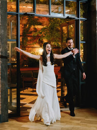 A high-energy real moment of a couple entering their reception at the Wythe Hotel, showcasing the vibrant atmosphere of a Brooklyn celebration.