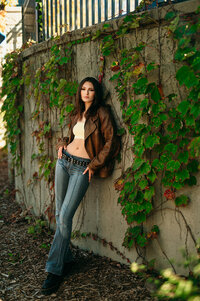 A student from Germantown High School leans against an ivy-covered wall at Boerner Botanical Gardens in Hales Corners while her senior photos are captured.