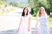 two senior girls walking towards the camera side by side and laughing.