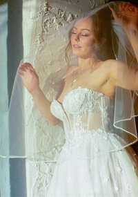 bride under veil gazing into the sunlight