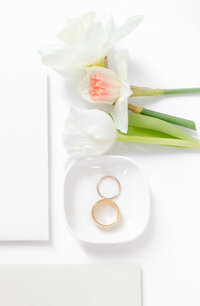 bright light and airy wedding photo of brides details ring shot flowers