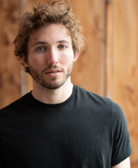 Young man with a serious look and curly red hair posing for a modeling portfolio