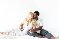 Expecting mother holding her baby bump in soft natural light in Bend, Oregon Studio.