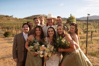 Bride surrounded by her bridesmaids holding bouquets in a group portrait