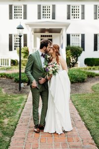 bride-groom-kissing-brick-walkway-white-estate