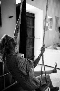 Boudoir experience in studio model smiling on swing
