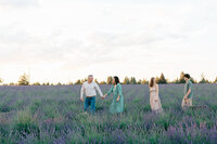 Family walking in an open field during a family session