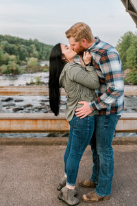 Couple kisses in front of rocks and water