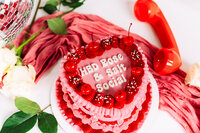 Close-up of the red and pink cake and styling details used in creative brand photoshoot.
