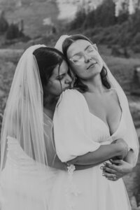Black and white wedding portrait of two newlyweds embracing outdoors during an intimate elopement photography session at Mount Rainier National Park in Washington.