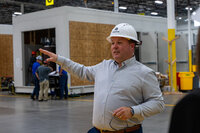A person in a hard hat pointing off to the side