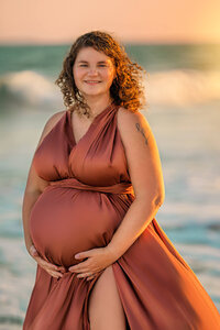 Pregnant mother in flowing dress during golden hour beach maternity session in Atlantic Beach North Carolina