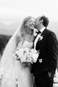 A couple leans in for a kiss, both smiling
