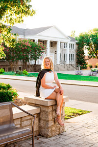 Senior girl sitting on a pillar during golden hour at Trevecca University in Nashville