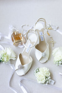 bridal flat lay of wedding shoes, perfume and flowers in detroit