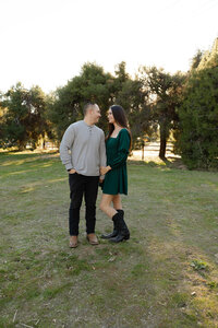Couple standing together in an open field with trees in the background, romantic golden hour portrait by Kaitlyn Dawn Photography, couples and family photographer.