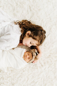 sister snuggling baby sister