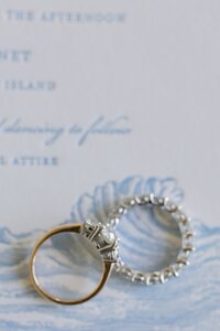 Wedding rings lay on letterpress stationary for Nantucket wedding.
