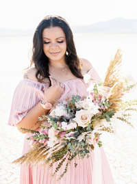 Kiamarie Stone holds bouquet in pink dress and looks down