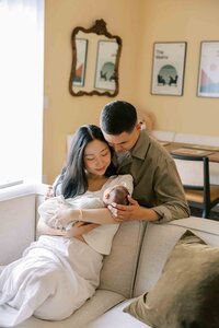 New parents gazing lovingly at their newborn baby girl during a Palo Alto newborn photography session