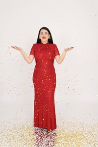 Vancouver boudoir photographer Gina Spanos in a red gown surrounded by gold confetti, celebrating confidence and beauty at her Burnaby studio.