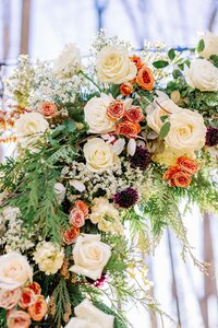 Winter floral arrangement detail with ivory roses, burnt orange blooms, and plum accents by Flowergirl Cville, Charlottesville VA florist | Photo by Xiaoqi Li Photography