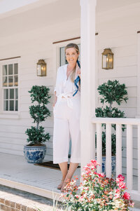 destination wedding photographer Kelsey Halm standing on a porch in Charleston South Carolina
